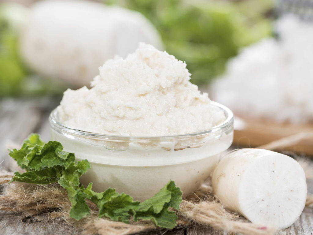 Horseradish Sauce in a small bowl on wooden background (close-up shot)