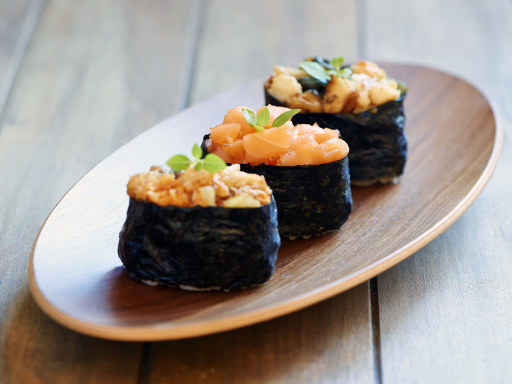 Tasty eel and salmon sushi on wooden plate