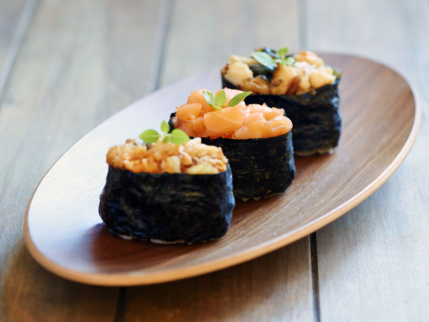 Tasty eel and salmon sushi on wooden plate