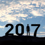 Person silhouette standing in 2017 on the hill at sunset