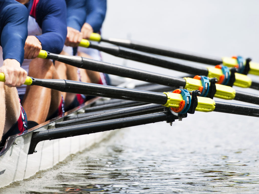 Close up of a men's quadruple skulls rowing team, seconds after the start of their race