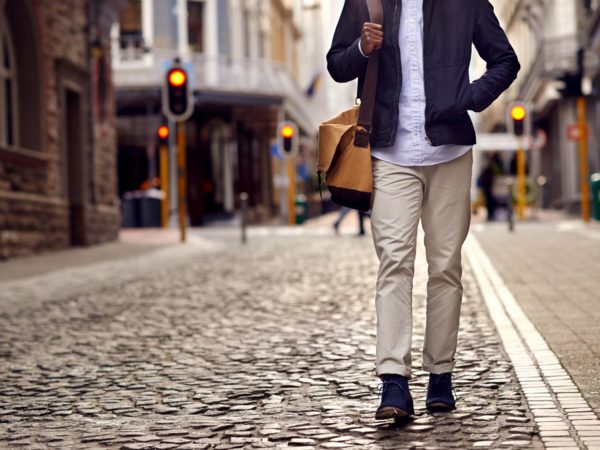 Young african man on vacation exploring european city cobblestone street