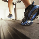 Man running in a gym on a treadmill concept for exercising, fitness and healthy lifestyle