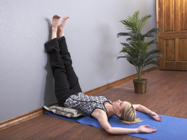 &quot;A young woman does the Legs Up The Wall Yoga Pose, viparita karani, in a yoga class. Shot with Canon 5D.&quot;