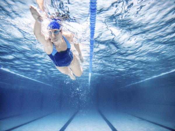 Under water shoot of a woman swimming freestyle in olympic pool