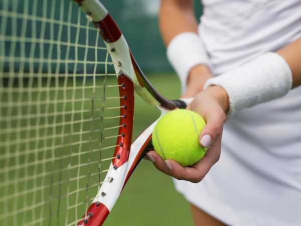Close-up of tennis player holding racket and ball in hands