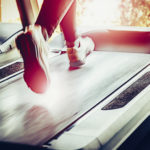 Woman running on treadmill in health club.