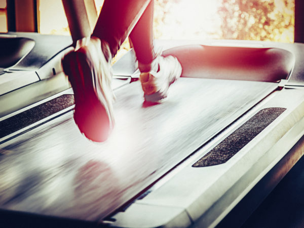 Woman running on treadmill in health club.