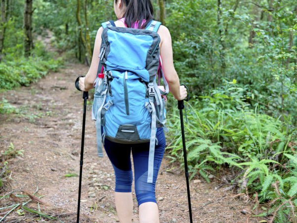 Young asian woman hiking in forest.