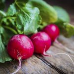 Radishes on rustic wooden background