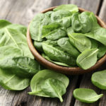 Fresh spinach on a wooden background