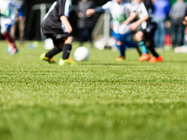 Picture of kids soccer training match with shallow depth of field. Focus on foreground.