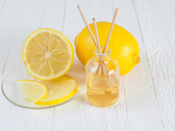 Fragrance sticks or bottle Scent diffuser with Lemon on wooden background.