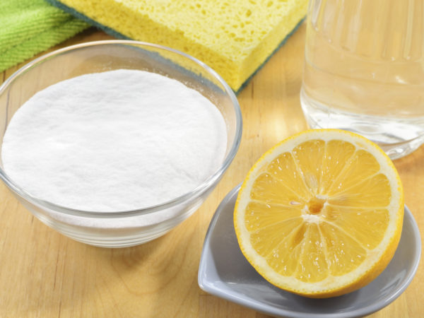 Eco-friendly natural cleaners. Vinegar, baking soda, salt, lemon and cloth on wooden table. Homemade green cleaning.