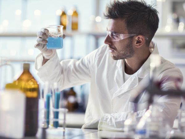 Young scientist working on scientific experiment with chemical substances.