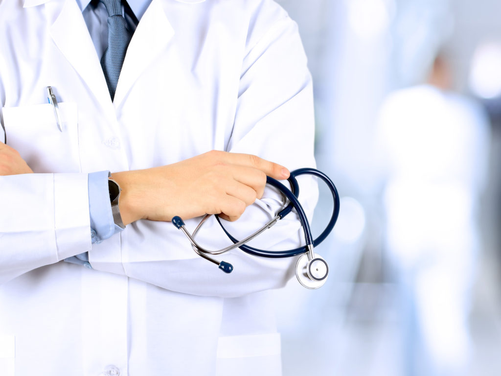 Portrait an unknown male doctor holding a stethoscope behind