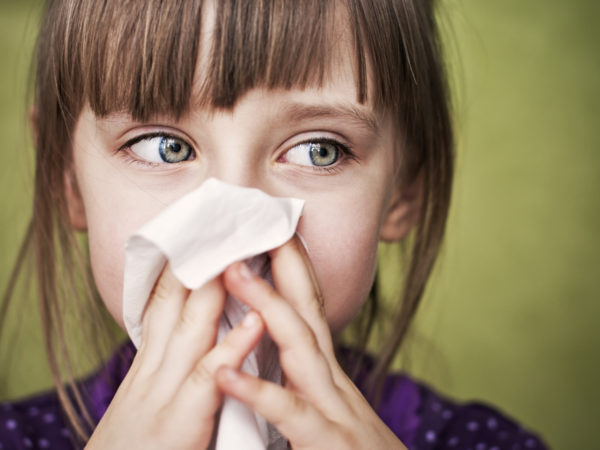 Little sick girl cleaning her nose