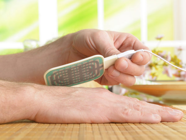 Electrotherapy, electrical stimulation using surface electrode pads with a conductor gel placed on the skin.