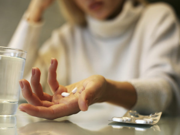 Close up of woman hands holding a pills.