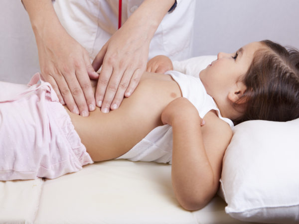 Pediatrician doing abdominal examination with hands