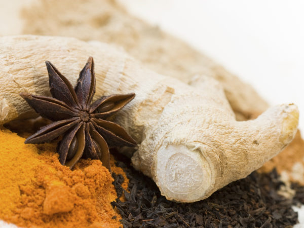 Decorative close-up image of spices like ginger, star anise, curcuma and black tea.