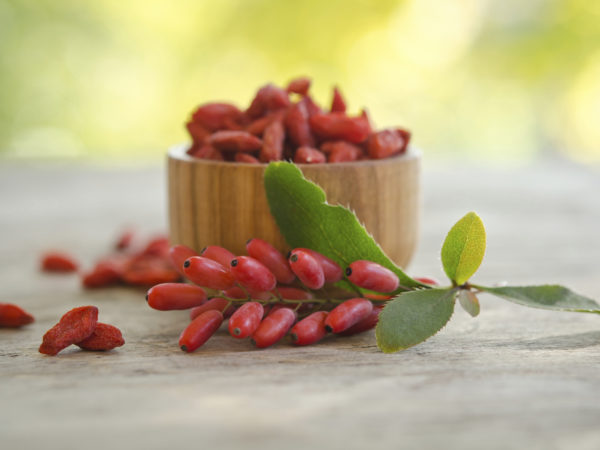 barberries and goji berries isolated on wooden table.