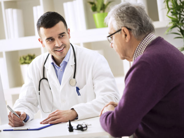 Doctor explaining prescription to senior patient, healthcare concept