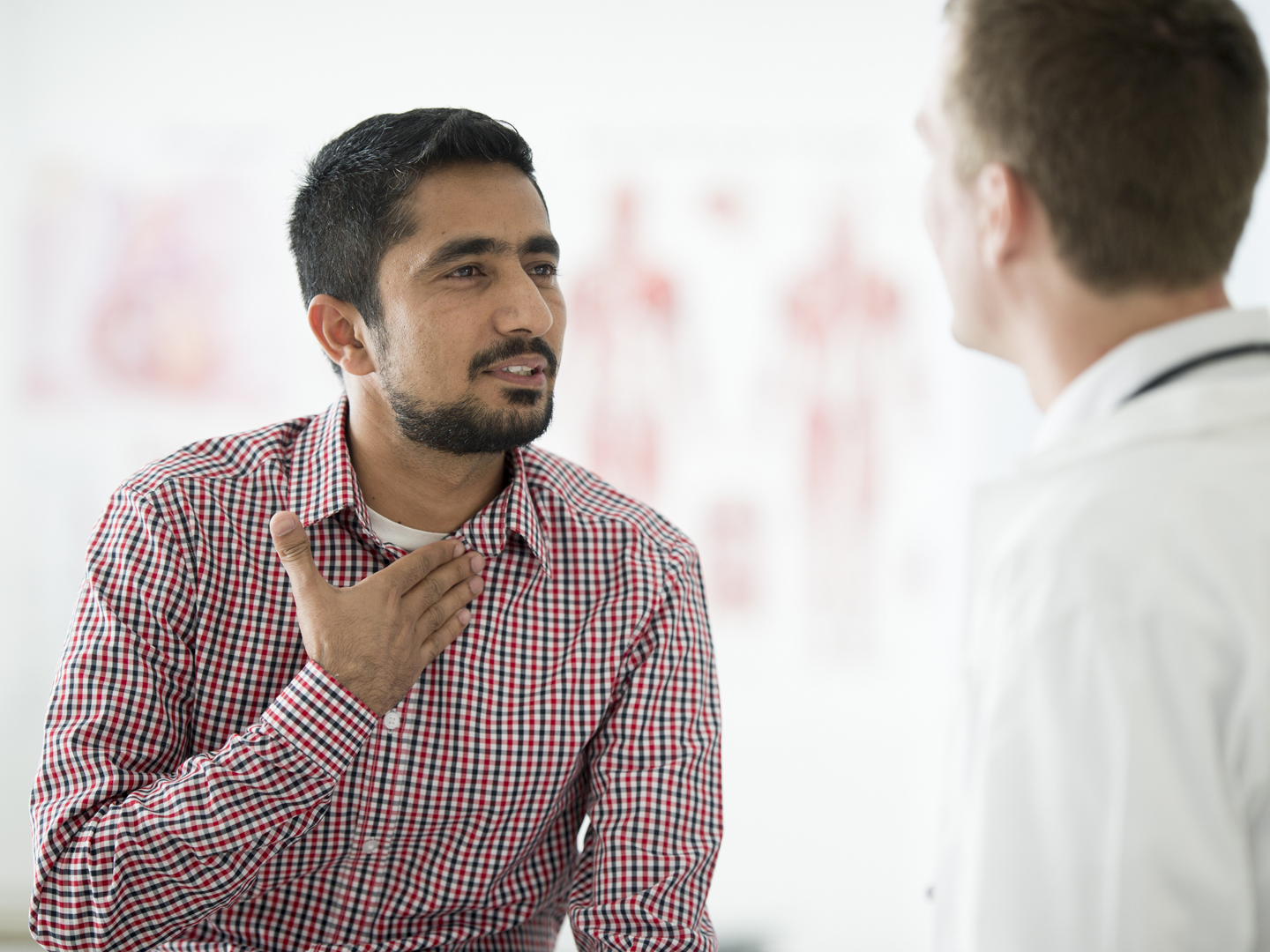 A man is going to the doctors office for a check up about his soar throat. The doctor is asking him medical questions.