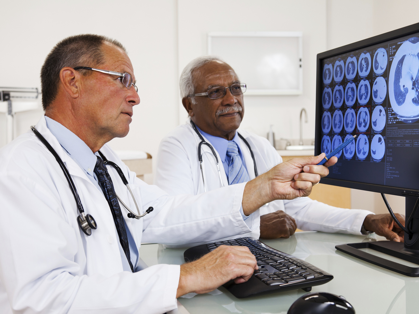 XXXL. Two doctors reviewing an MRI scan on the computer.