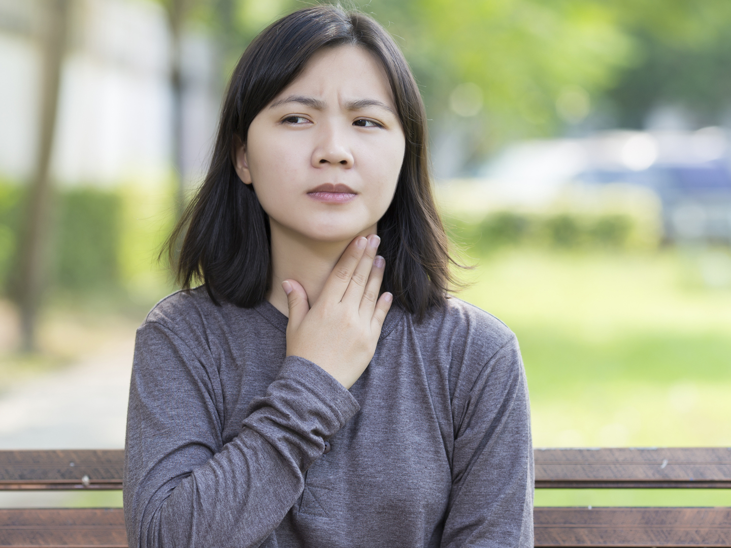 Woman has Sore Throat at Park