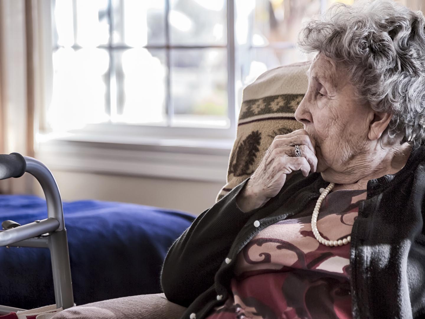 Portrait of an elderly woman sitting alone in a senior care facility