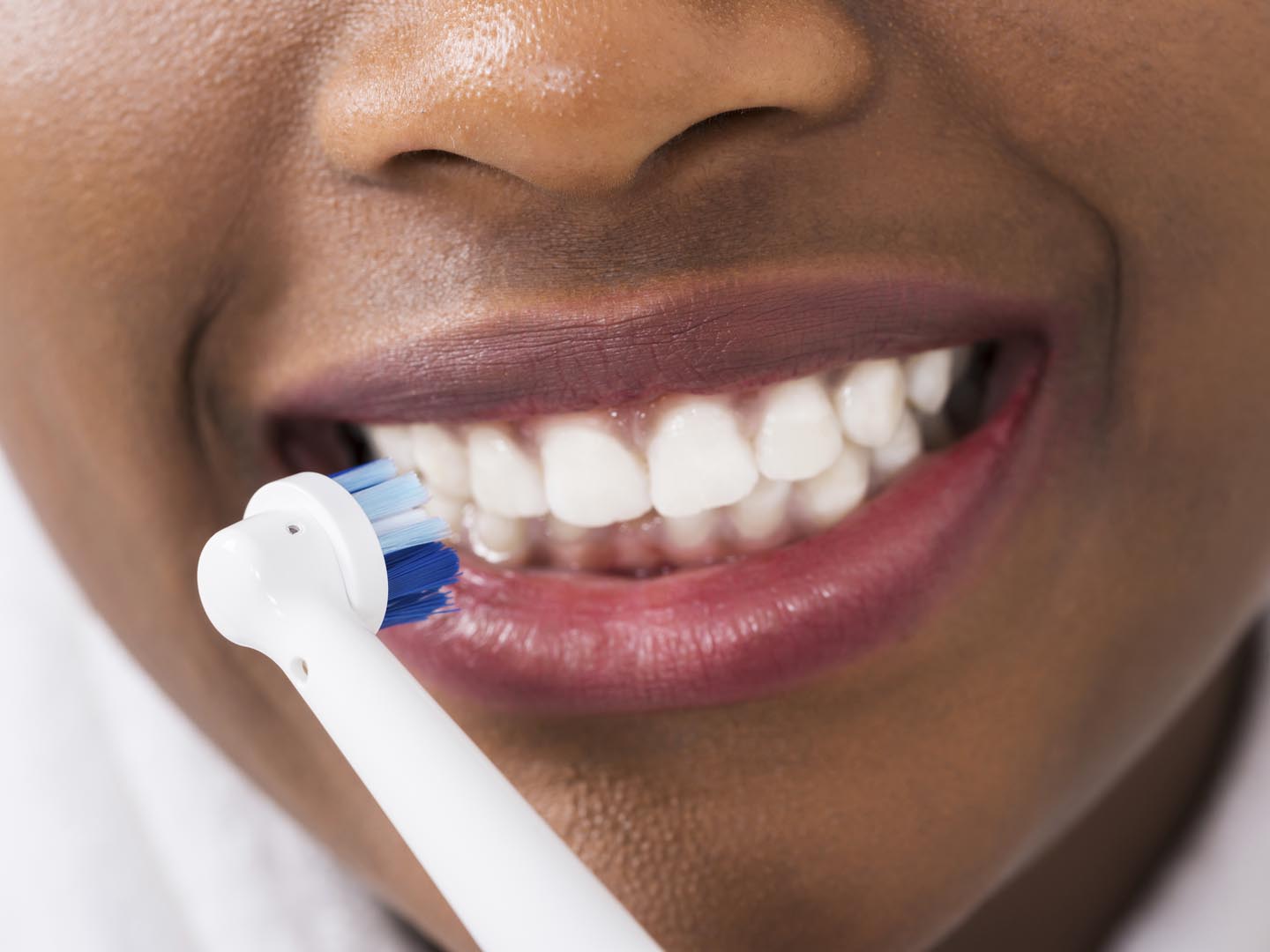 Close-up Of A Woman Brushing Teeth With Electric Toothbrush