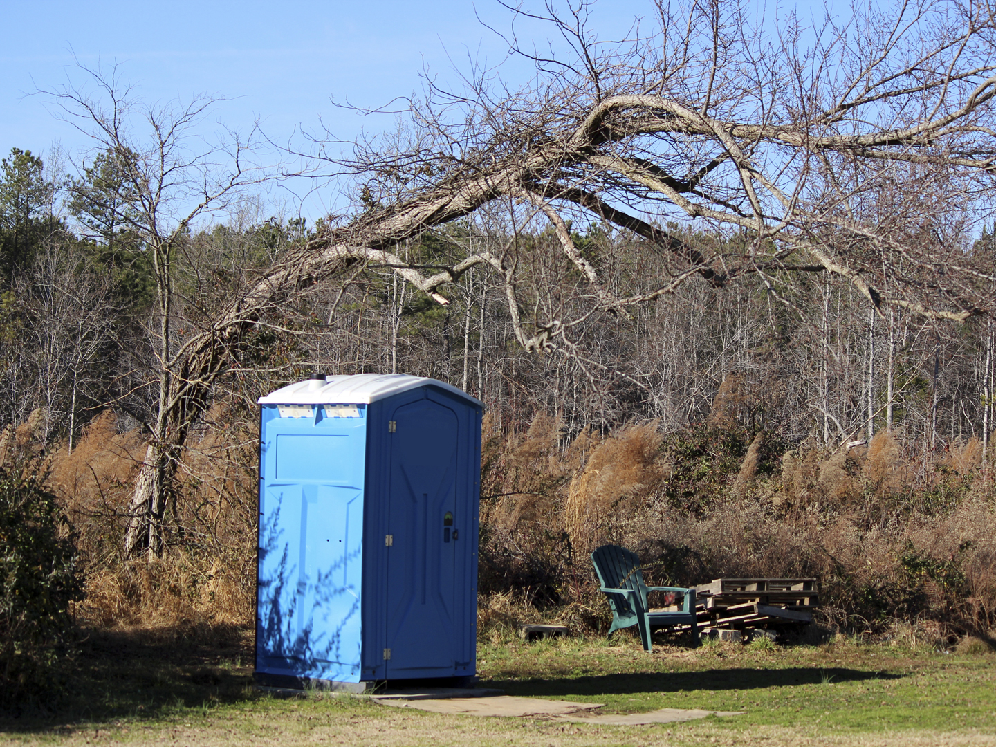 This portable toilet is located near a hobby airport.
