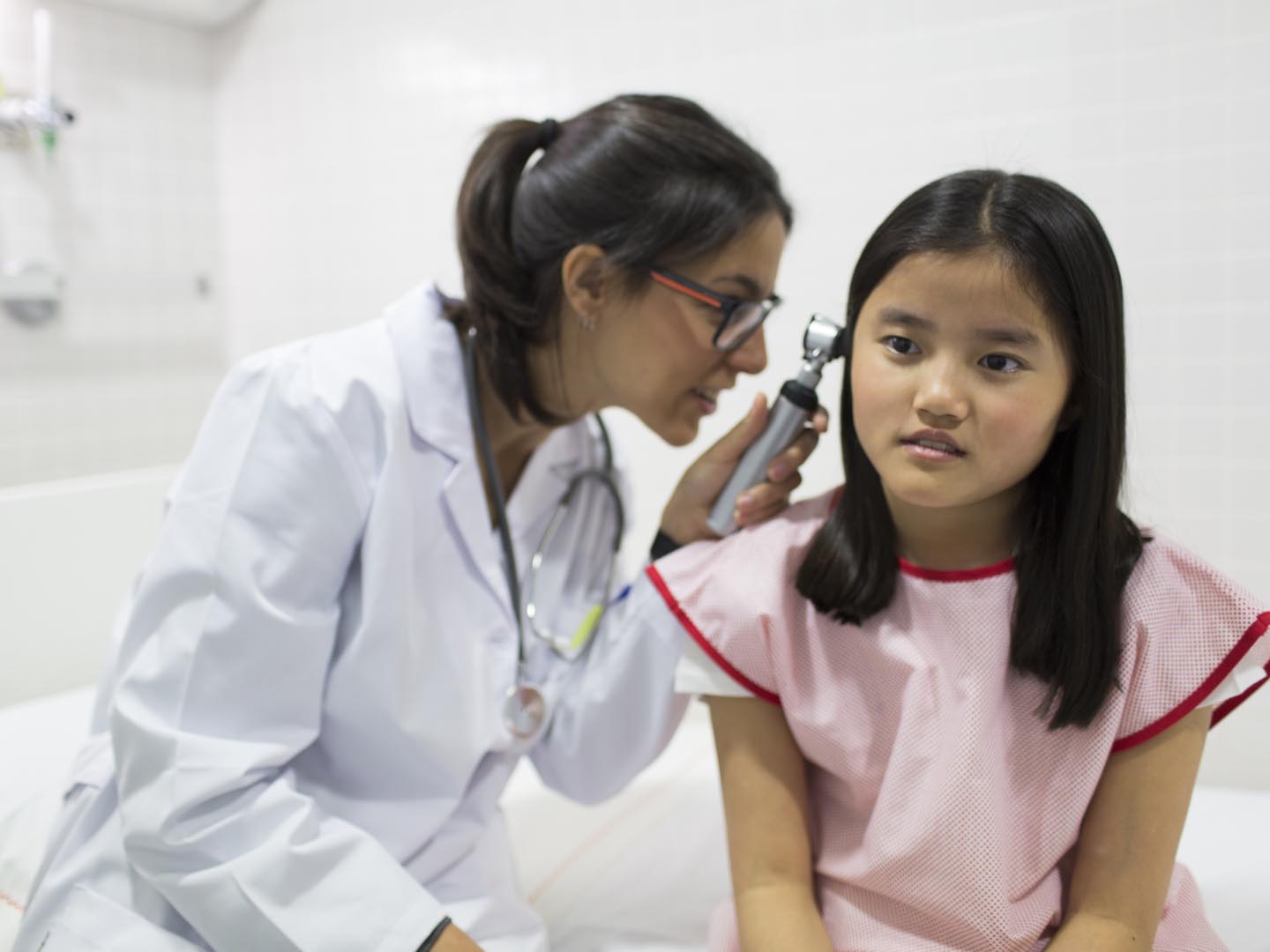 Paediatrician with asian girl at the hospital.