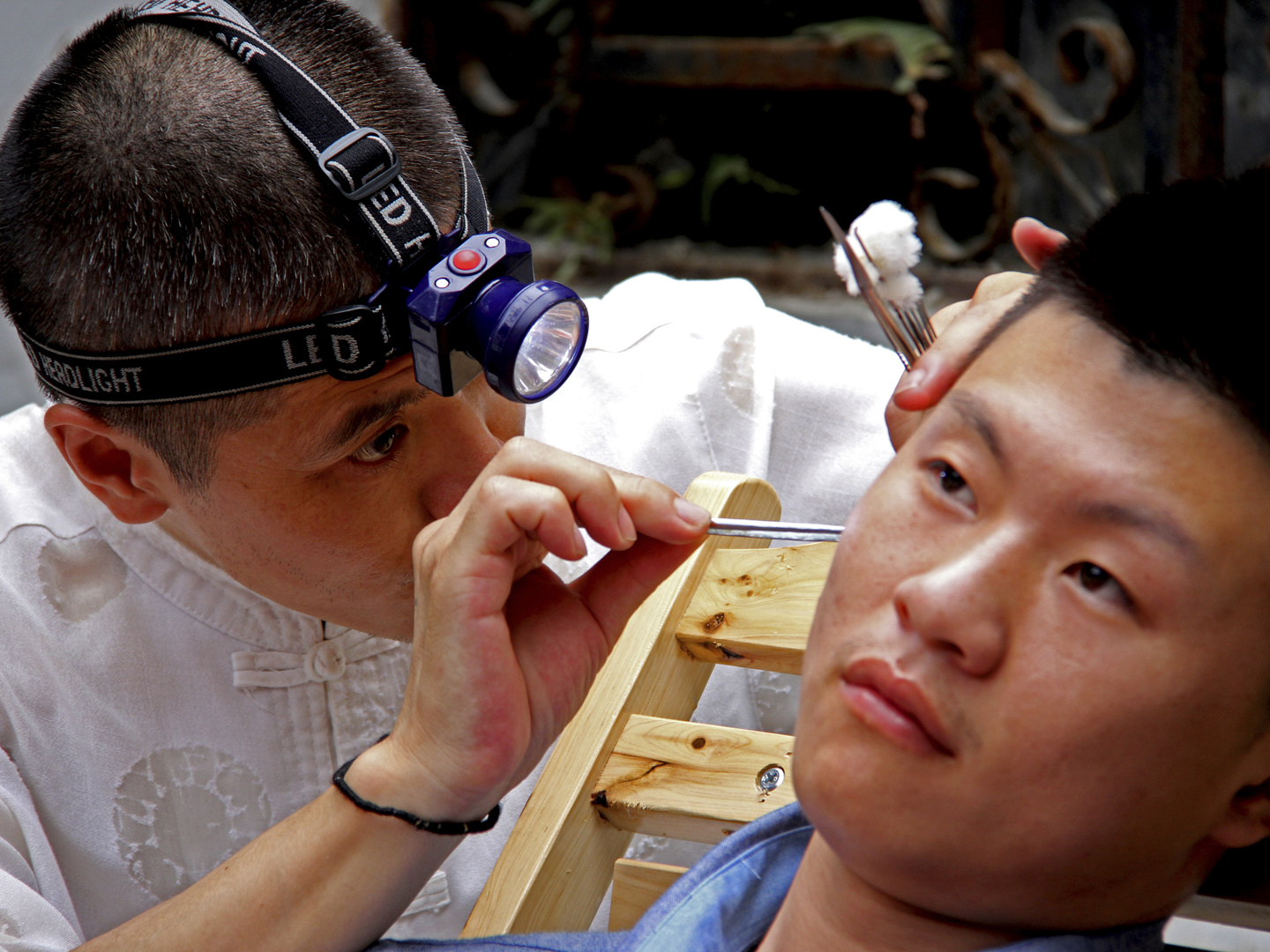 Chengdu, China - August 5, 2013: Ear Wax Removal in Chengdu marketplace