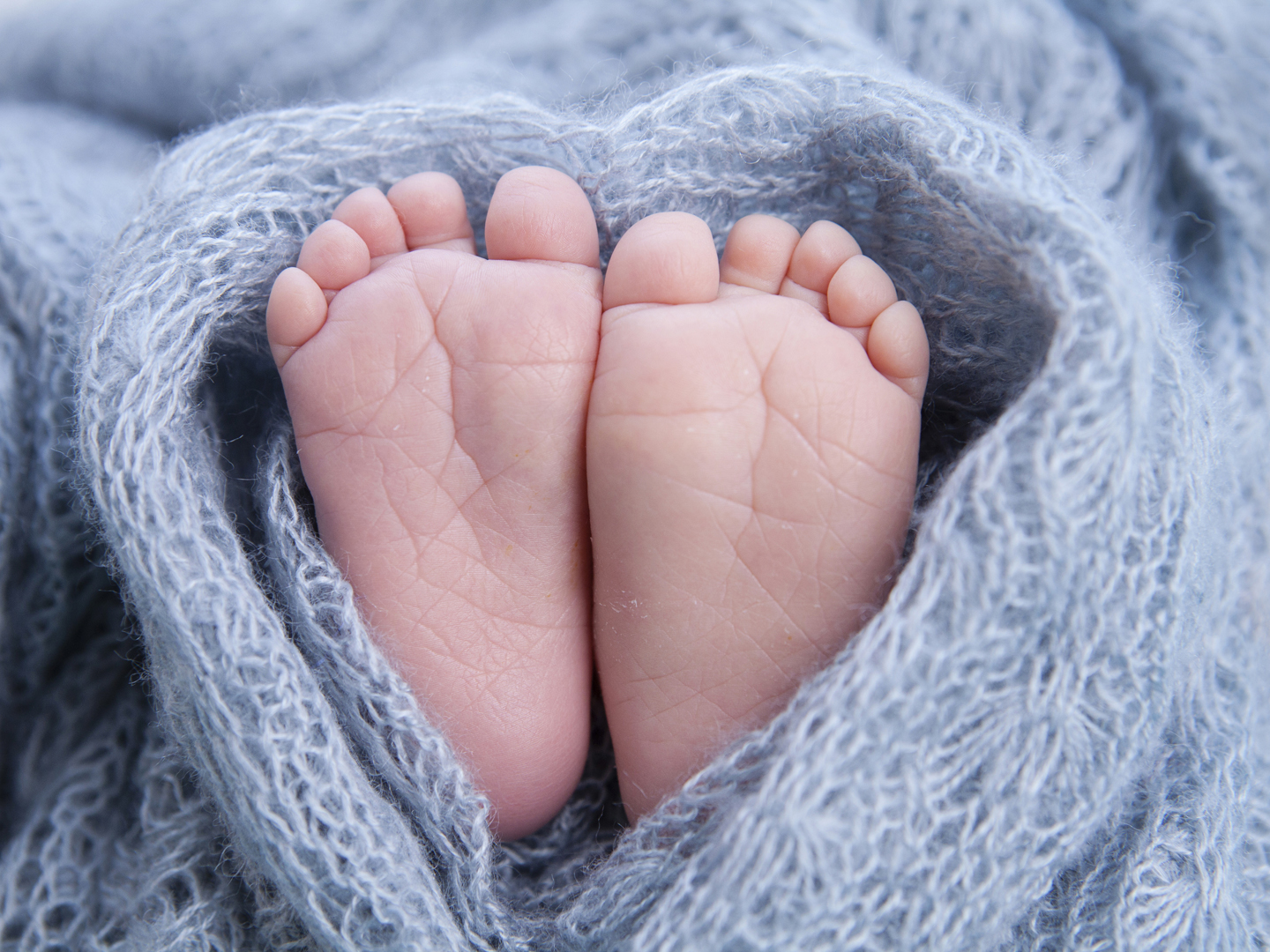 Little toes, baby feet wrapped in a heart blanket