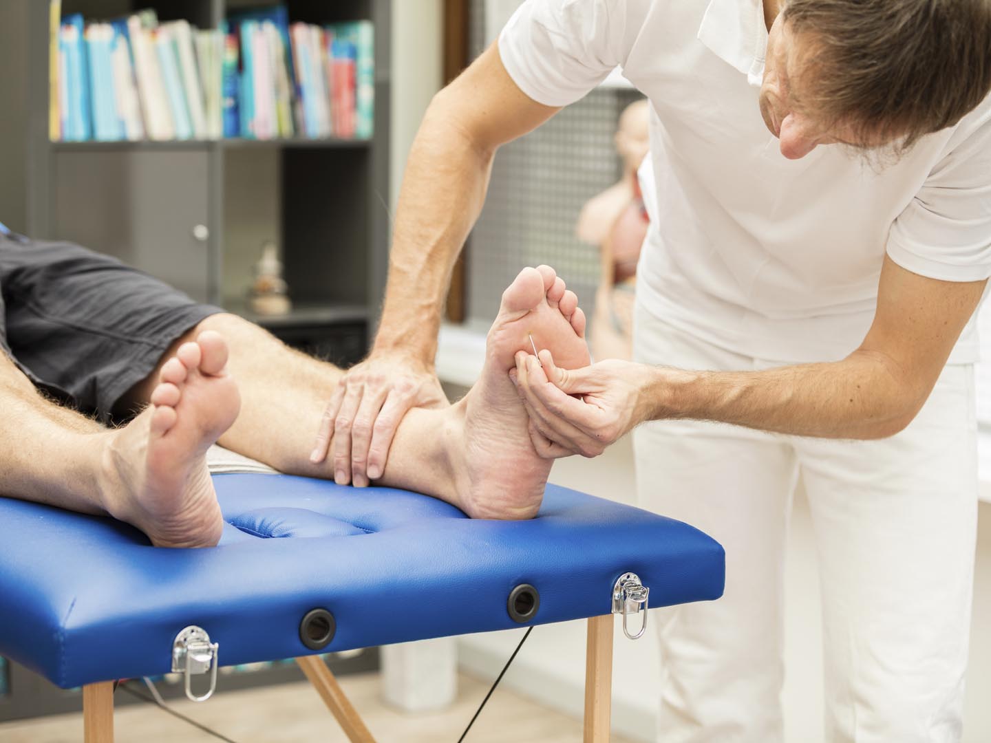 A  doctor, testing the sensibility  of a patient`s foot. This test is often used for checking neuropathy of diabetic patients. XXXL size image.