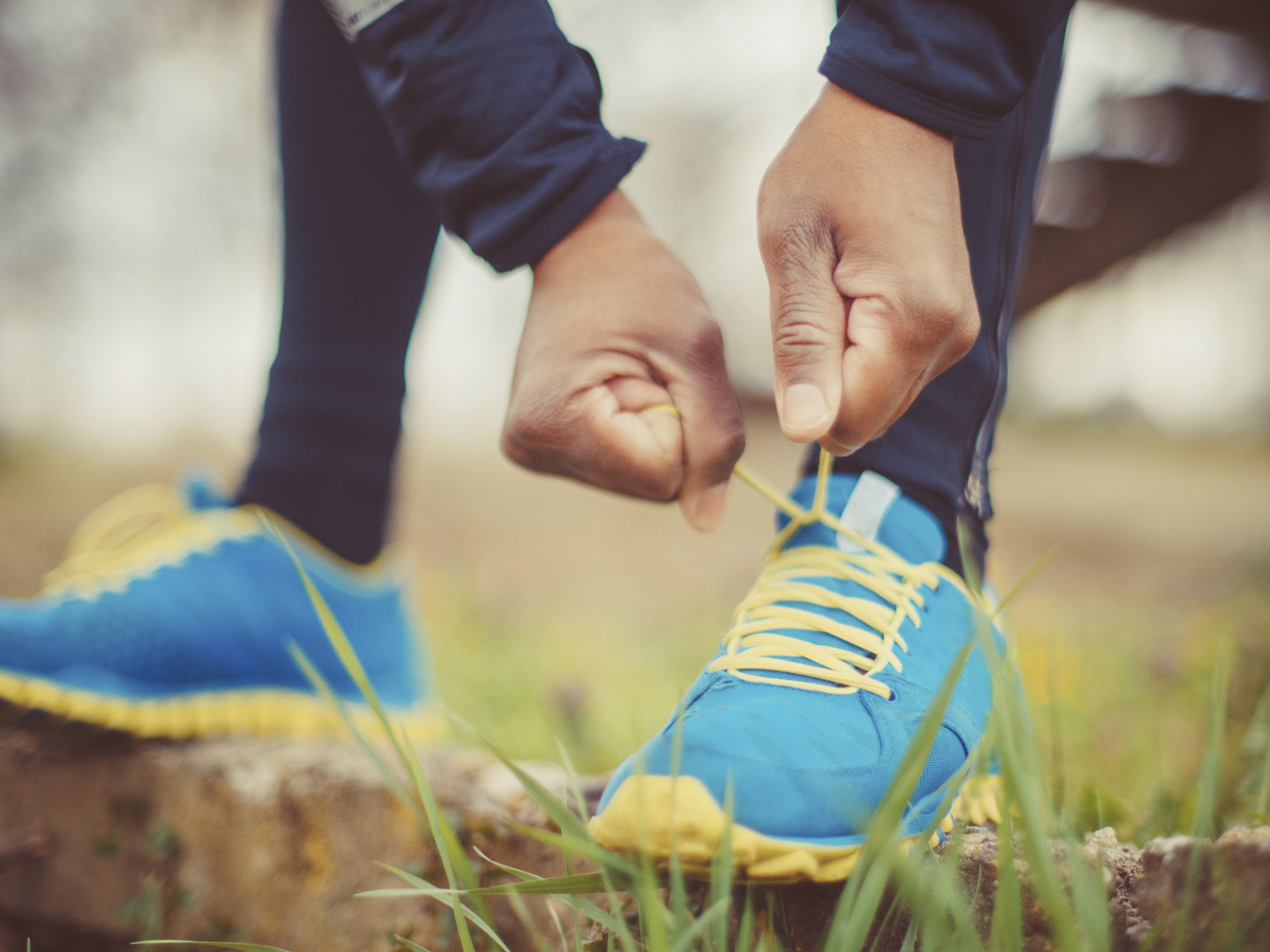 close up of runner tying his shoes preparing for a run a jog outside