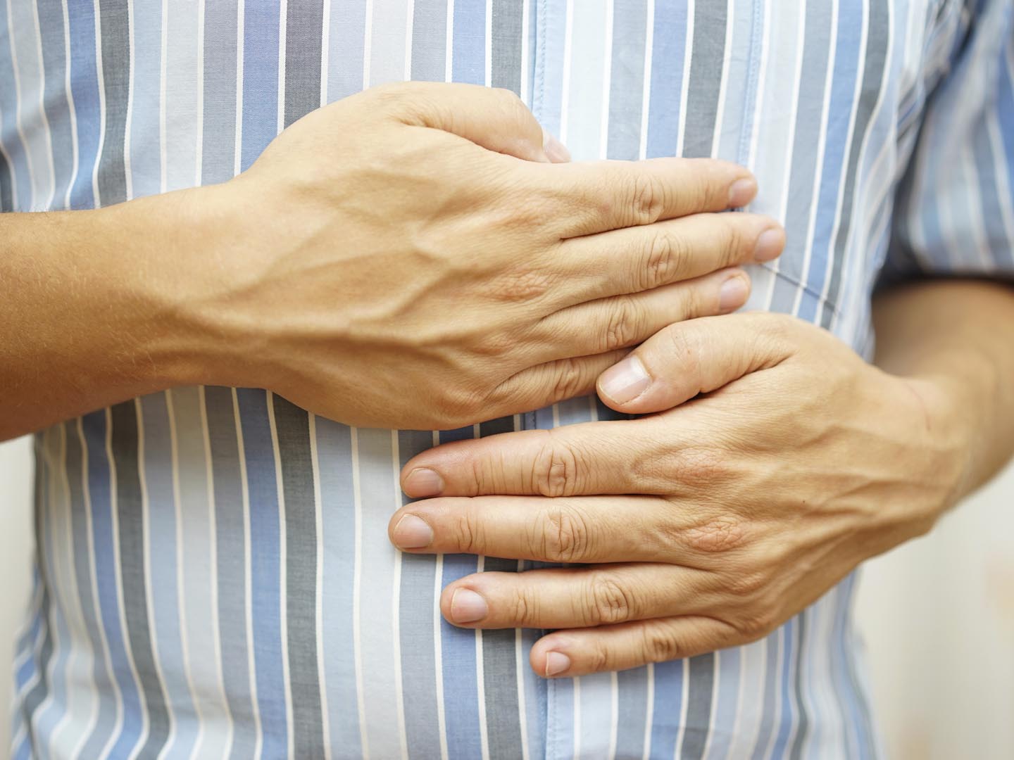 Stomach ache, man placing hands on the stomach, concept of .stomach ulcer