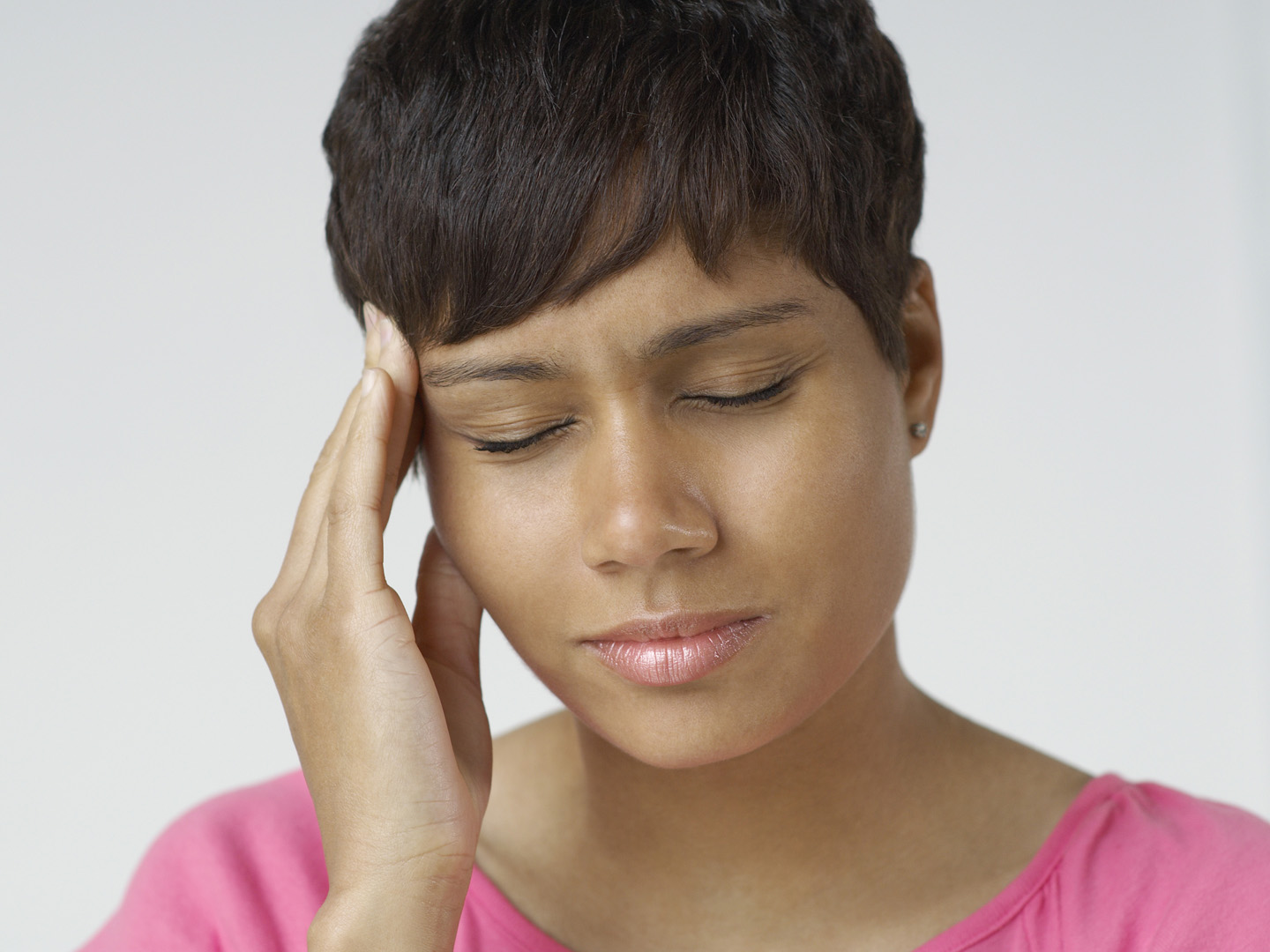 Woman with hand on forehead, indoors