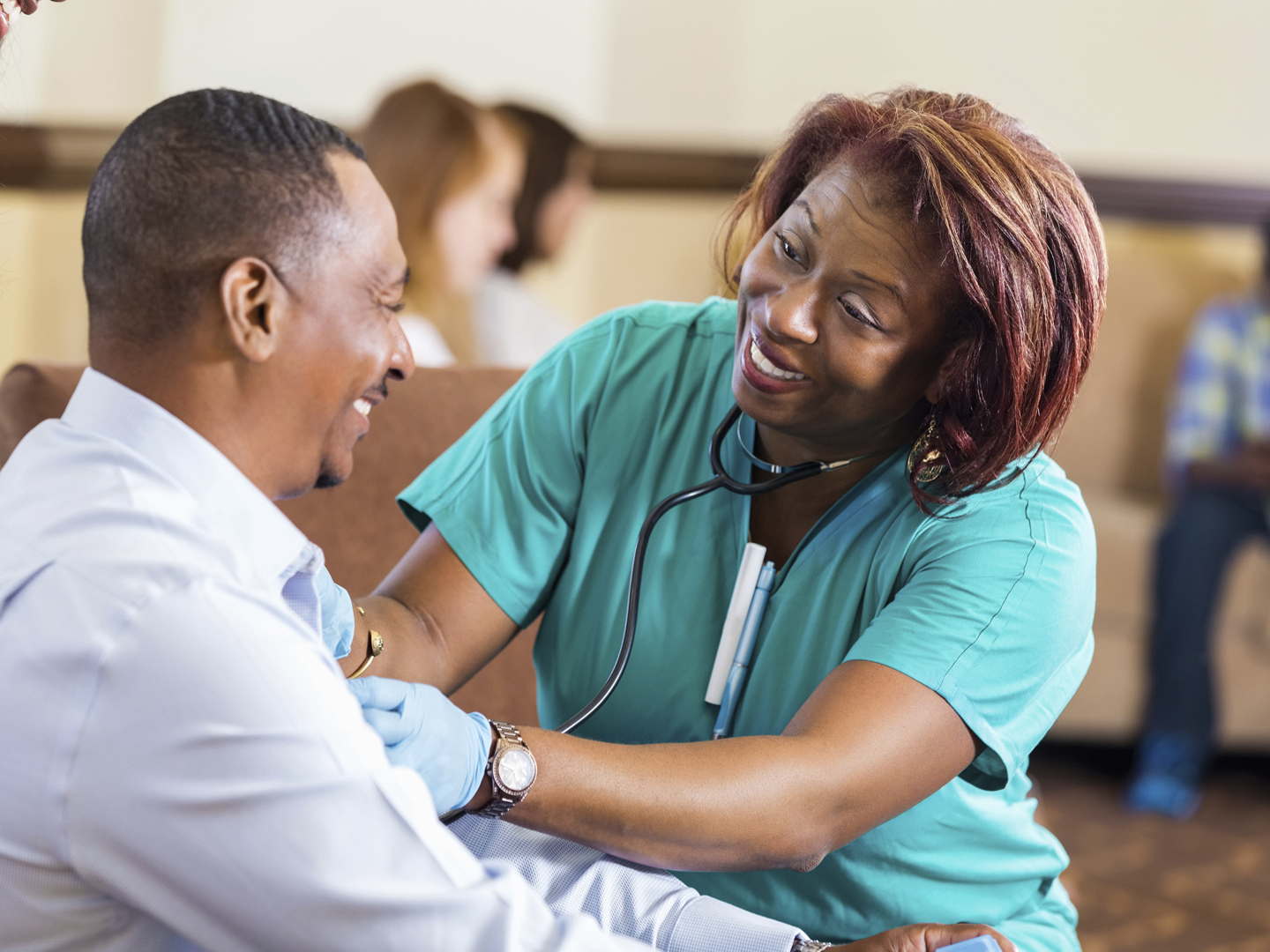 Nurse checking blood pressure for mature African American man