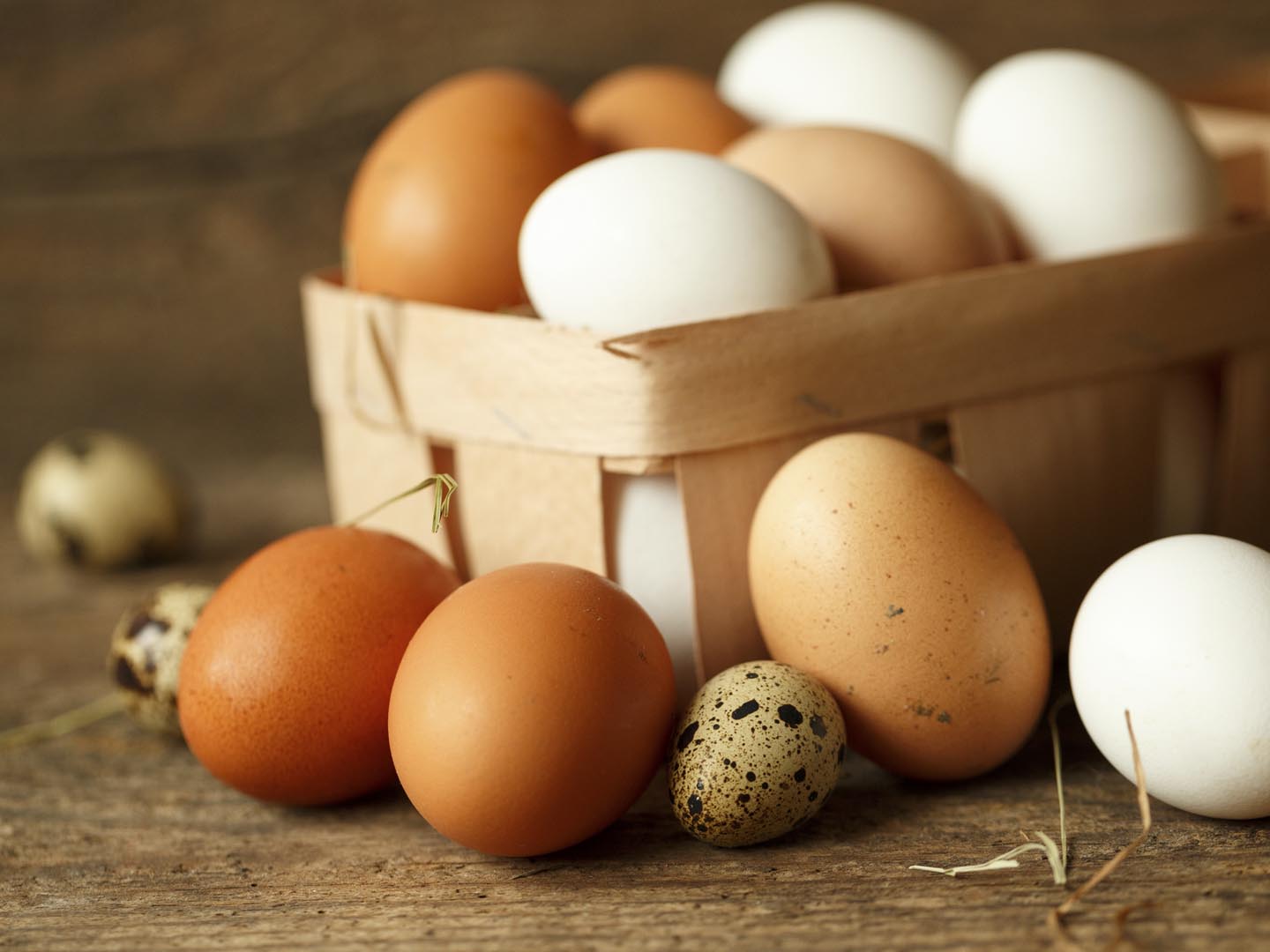 Fresh chicken and quail eggs on a wooden rustic background