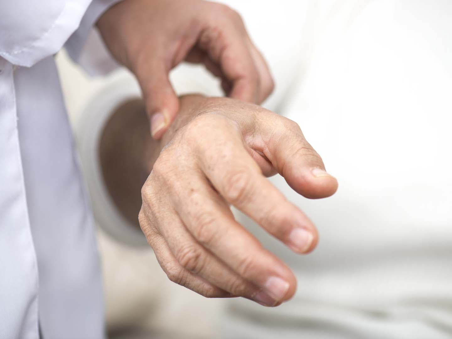 Doctor checking the pulse of an elderly woman.