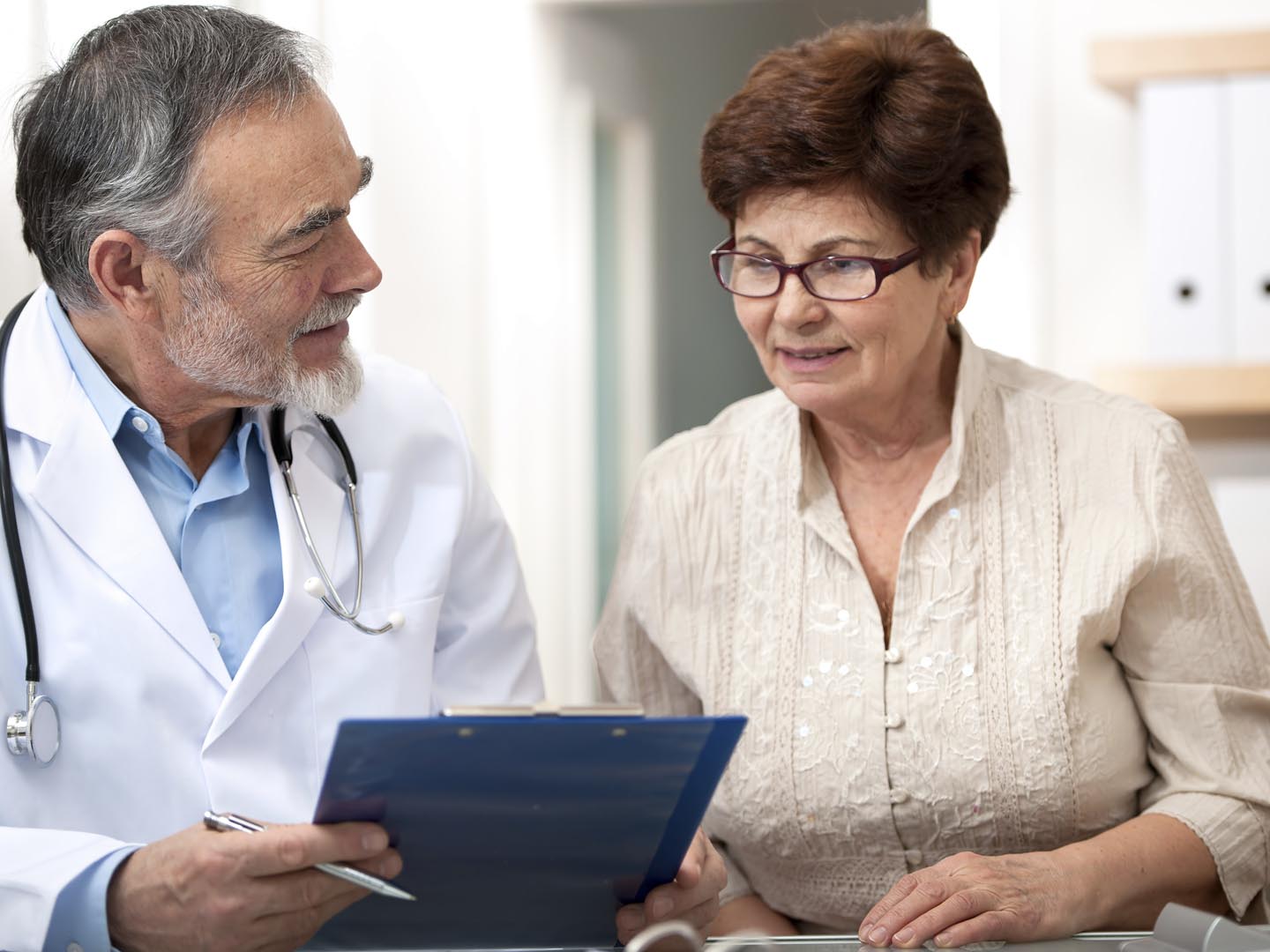 Doctor discussing treatment with senior female patient