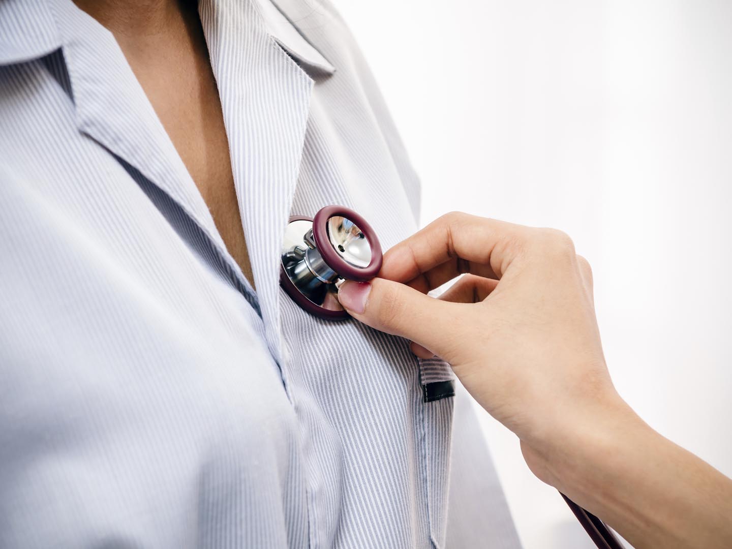 doctor listening to patient’s heartbeat with stethoscope