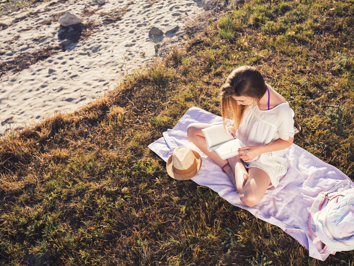 woman reading book on grass