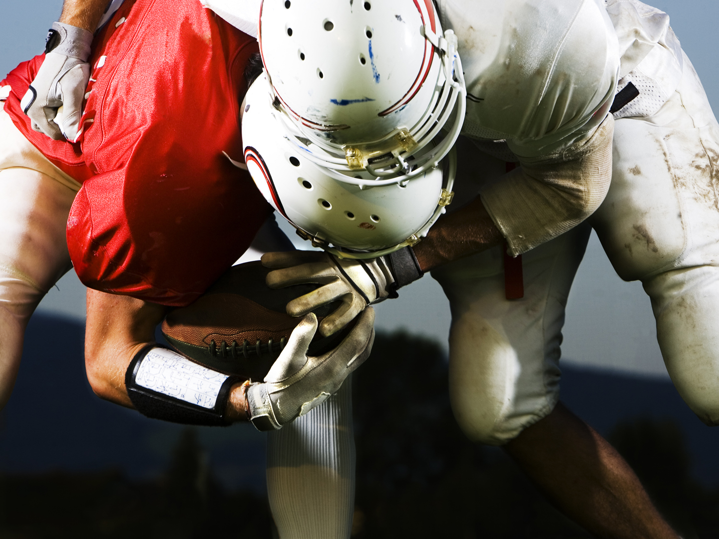 two football players in heavy interaction, fighting for the ball