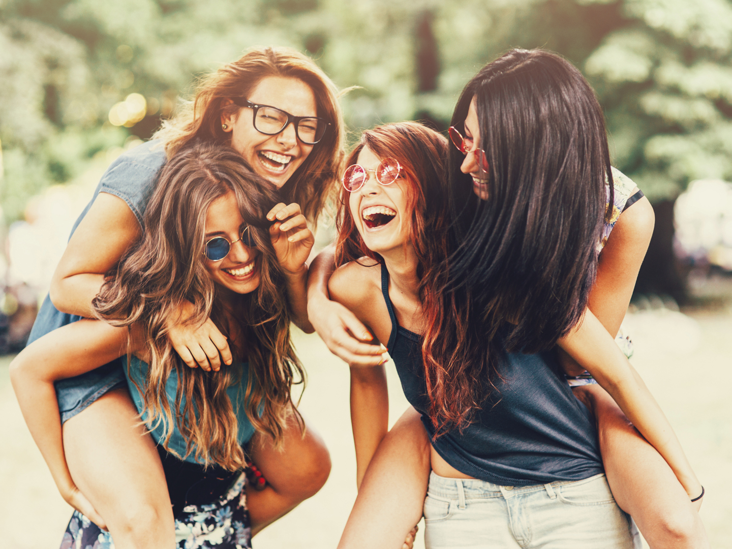 Girls havin fun holding their friends on piggyback.