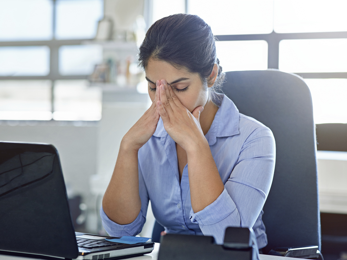 Shot of a businesswoman experiencing stress at work