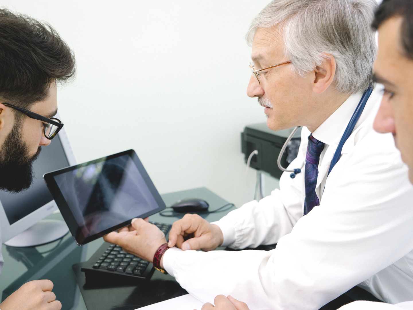 Mature doctor using a digital tablet for his diagnosis.